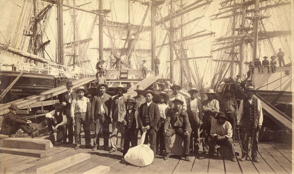 Longshoremen, many of them Indigenous, at the Moodyville Sawmill in Vancouver, 1889. Some, William Nahanee (centre, with laundry bag) later founded the Bows and Arrows IWW local. Photo: City of Van Archives Mi P2