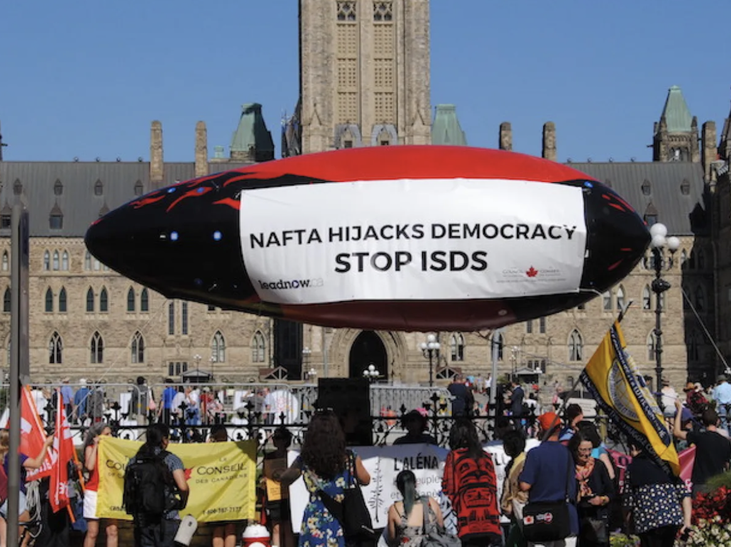 A protest outside the Canadian Parliament, with protesters demanding to "Stop ISDS"