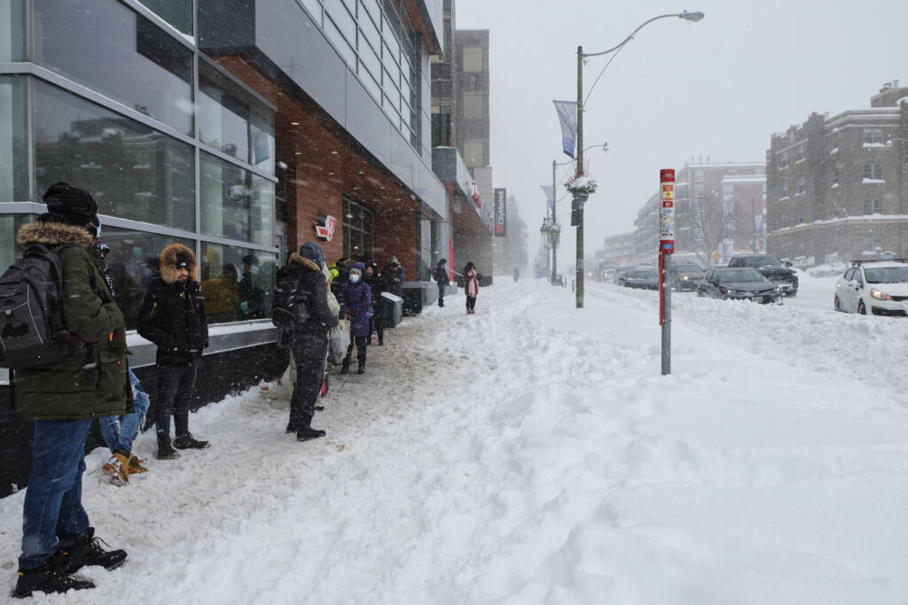 Commuters wait outdoors in inclement weather for a Toronto bus in January 2022.